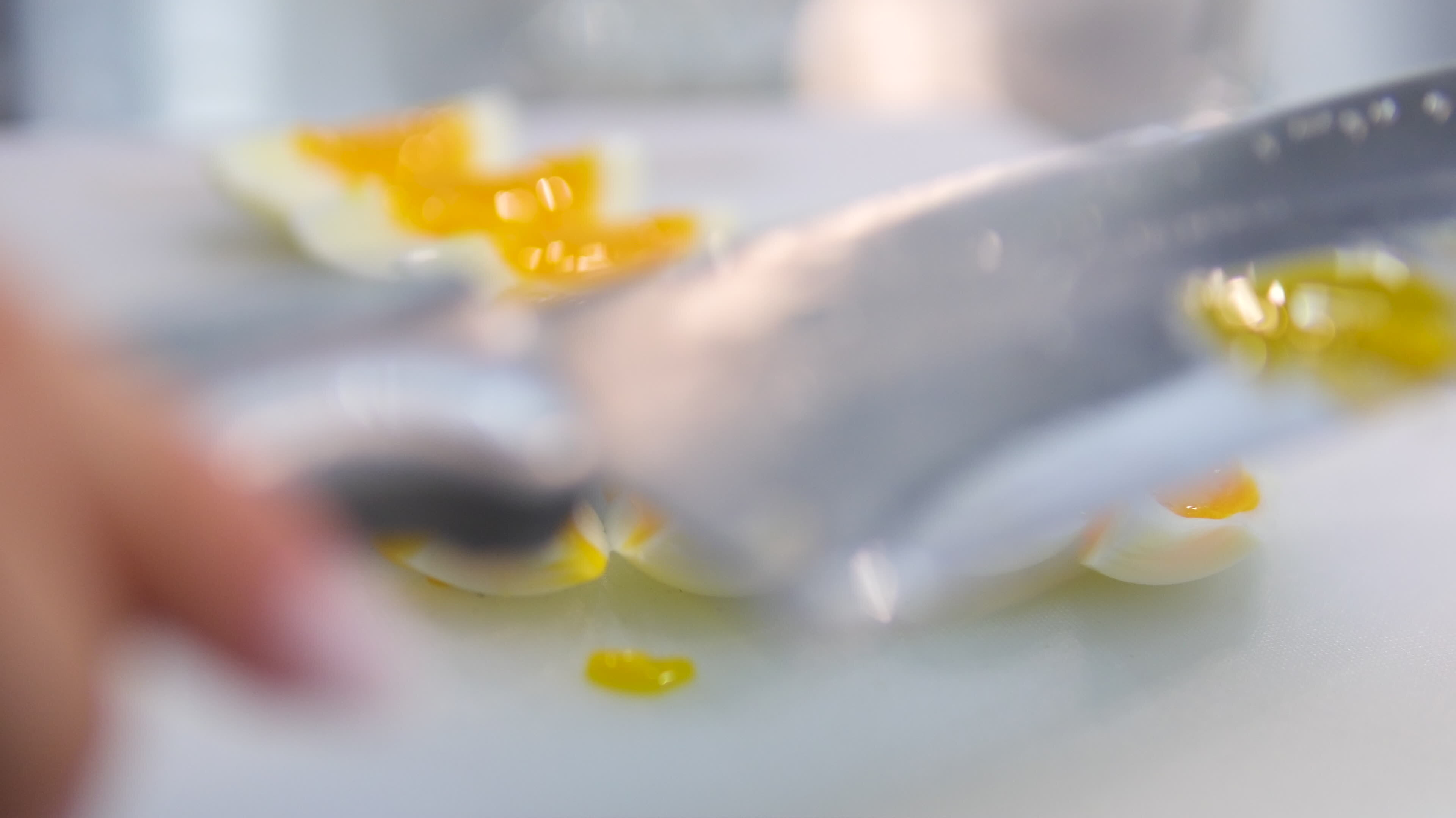 Cutting boiled eggs Cooking Crab Salad. Female hand cuts boiled eggs