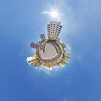 abstract swirling tiny planet spherical panorama of multi-storey buildings of skyscrapers of a residential complex in the form of a butterfly, bugs, crabs in blue sky photo