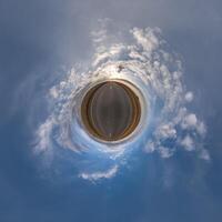 simple little tiny planet without buildings in blue sky with beautiful clouds. Transformation of spherical panorama 360 degrees. Spherical abstract aerial view. Curvature of space. photo