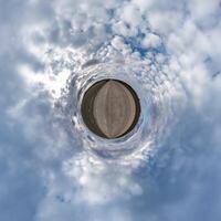 simple little tiny planet without buildings in blue sky with beautiful clouds. Transformation of spherical panorama 360 degrees. Spherical abstract aerial view. Curvature of space. photo