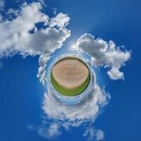 simple little tiny planet without buildings in blue sky with beautiful clouds. Transformation of spherical panorama 360 degrees. Spherical abstract aerial view. Curvature of space. photo