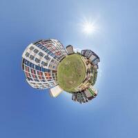 abstract swirling tiny planet spherical panorama of multi-storey buildings of skyscrapers of a residential complex in the form of a butterfly, bugs, crabs in blue sky photo