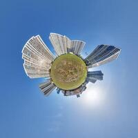abstract swirling tiny planet spherical panorama of multi-storey buildings of skyscrapers of a residential complex in the form of a butterfly, bugs, crabs in blue sky photo