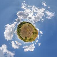simple little tiny planet without buildings in blue sky with beautiful clouds. Transformation of spherical panorama 360 degrees. Spherical abstract aerial view. Curvature of space. photo