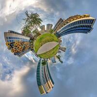 abstract swirling tiny planet spherical panorama of multi-storey buildings of skyscrapers of a residential complex in the form of a butterfly, bugs, crabs in blue sky photo