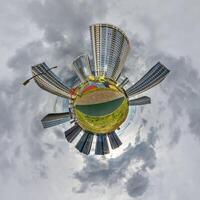 abstract swirling tiny planet spherical panorama of multi-storey buildings of skyscrapers of a residential complex in the form of a butterfly, bugs, crabs in blue sky photo