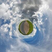 simple little tiny planet without buildings in blue sky with beautiful clouds. Transformation of spherical panorama 360 degrees. Spherical abstract aerial view. Curvature of space. photo