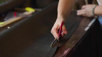 Tailor Cutting a Hard Fabric with Scissors to Make a Bag video