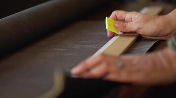 Tailor Pointing a Line to Cut a Hard Fabric to Make a Bag video