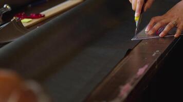Tailor Cutting a Hard Fabric with Scissors to Make a Bag video