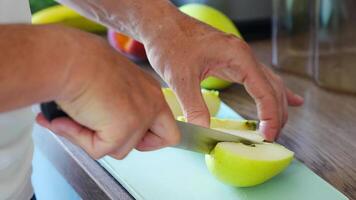Close up view of hand of man preparing apples for a healthy juice or smoothie in home kitchen. High quality 4k footage video