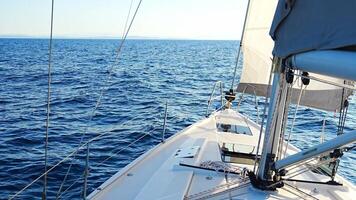 Yacht sailing in an open sea. Close-up view of the deck, mast and sails. Yachting concept. High quality 4k footage video