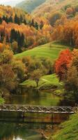 Idyllic Countryside Scene During Fall with Rolling Hills, Colorful Trees, and a Serene Creek. Concept of Autumn Landscape, Nature, Tranquility, Scenic View. Vertical photo