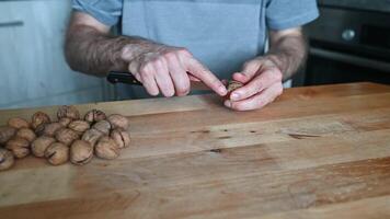 hands of a man cracking walnuts with a nutcracker video