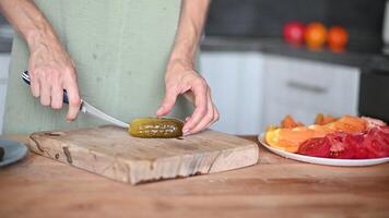 Woman slicing Salted pickles with knife from jar can, Cucumbers preservations, conservation. Salted pickled cucumbers in a wooden table. Preparing the salad video