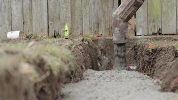pouring concrete into an excavation in the ground. concreting of the foundation of the new building video