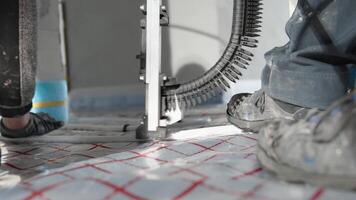 manual installation of underfloor heating in a new building. professional worker video