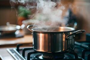 Steaming stainless steel pot on stovetop, misty kitchen atmosphere, blurred objects photo