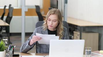 Portrait of businesswoman checking and comparing each marketing report, analyzing statistics data in charts. Young woman working on computer alone in modern office. video