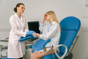 Sad woman is talking and shaking hands with a gynecologist in woman consultation during appointment photo