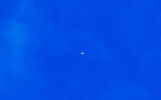 Passenger airplane flies in blue sky with clouds in Mexico. photo