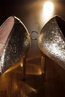 A pair of shoes with a ring on the left shoe photo