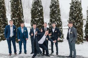A group of men in suits are posing for a picture in the snow. They are all smiling and seem to be enjoying themselves photo