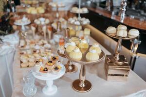 A table full of desserts including cakes, cupcakes, and pastries. The table is set up for a party or event photo