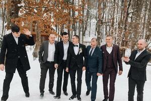 A group of men in suits are posing for a picture in the snow. Scene is lighthearted and festive, as the men are dressed up and enjoying the winter weather photo
