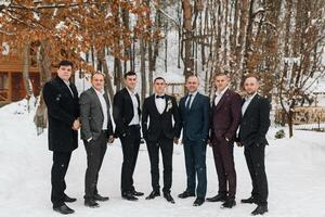 A group of men in suits are posing for a photo in the snow. Scene is formal and elegant, as the men are dressed in suits and ties. The setting of the photo is a snowy landscape