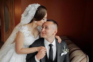 A man and a woman are hugging each other on a couch. The man is wearing a suit and tie photo