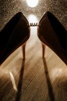 Two pairs of shoes with a crown on one of them. The crown is on the right shoe photo