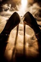 A pair of high heels with a ring on the left shoe and a ring on the right shoe photo