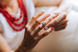 A woman is holding a ring in her hand, and it is a wedding ring. Concept of love and commitment, as the woman is holding the ring that symbolizes her relationship with her partner photo