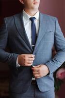 A man in a suit and tie is adjusting his jacket. Concept of formality and professionalism, as the man is dressed in a suit and tie photo