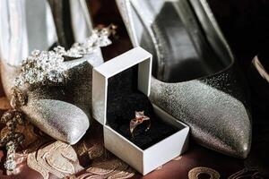 A silver box with a ring inside it is placed on a red carpet photo
