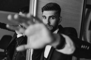 A man in a suit is posing with his hands up in the air. The image has a mood of confidence and professionalism photo