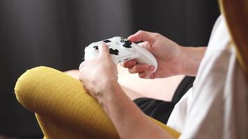 The woman is holding a white jostic, joystick, navigation key, cursor buttons, navigation control. She plays the game on the console. Close up video