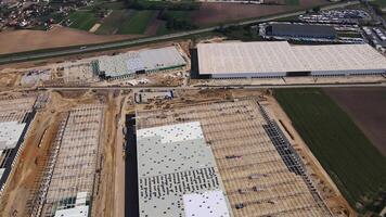Aerial view of construction site with warehouse building under construction for storage. Assembling industrial building with steel frame structure and roof truss. Infrastructure for logistics video