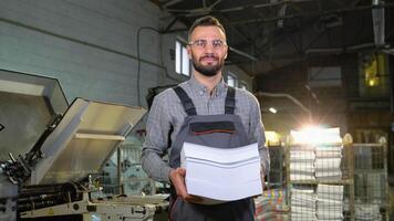 Portrait of print worker with paper for printing video