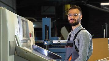 Portrait of technician operator near modern offset printing machine. video