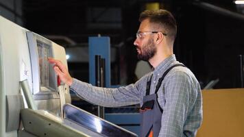 Print house worker setting parameters on modern offset printing machine video