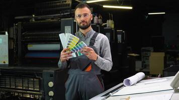 Designer holding swatch palette in hand at print factory video