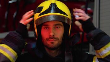 Firefighter putting on protective helmet and preparing for action while standing in fire station video