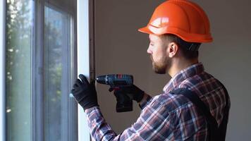 Handyman fixing the window with screwdriver. Construction worker installing window in house video