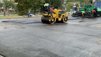 Ternopil, Ukraine October 25, 2023. Vibratory asphalt rollers compactor compacting new asphalt pavement. Road service build a new highway video