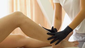 Professional waxing depilation, a master performing waxing depilation on a client leg video
