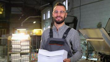 Portrait of print worker with paper for printing video
