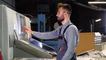 Technician operator checking input and output status on touchscreen front display monitor station at print plant factory video