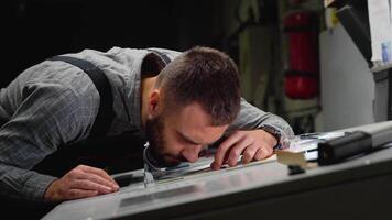 Worker in a printing and press center uses a magnifying glass and check the print quality video
